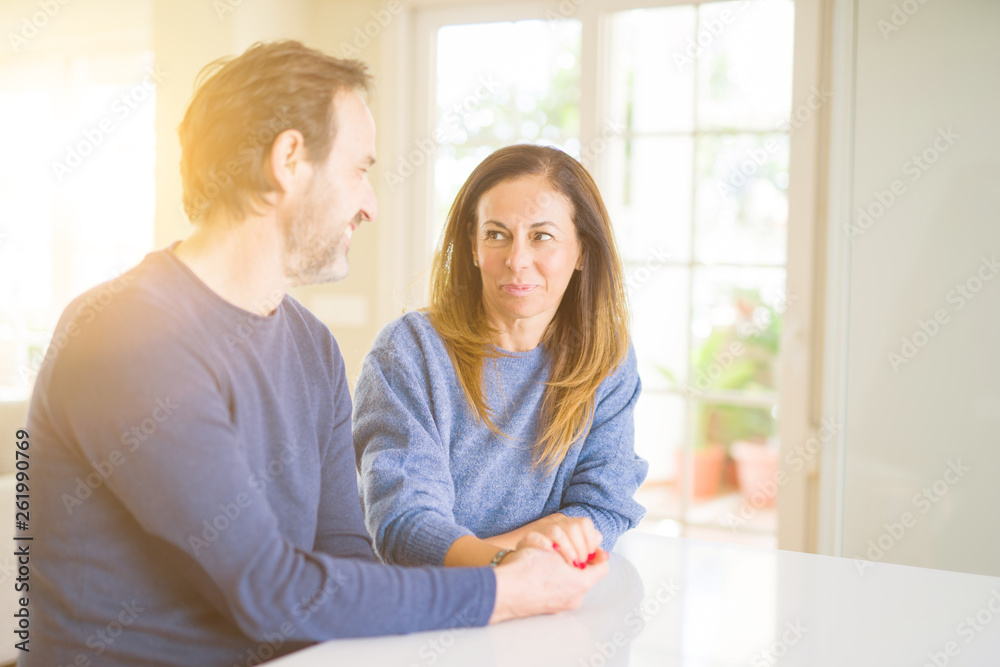 Romantic middle age couple sitting together at home Romantic middle age couple sitting together at home