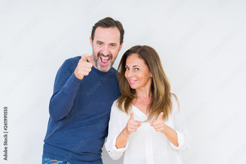 Beautiful middle age couple in love over isolated background pointing fingers to camera with happy and funny face. Good energy and vibes. Beautiful middle age couple in love over isolated background pointing fingers to camera with happy and funny face. Good energy and vibes.
