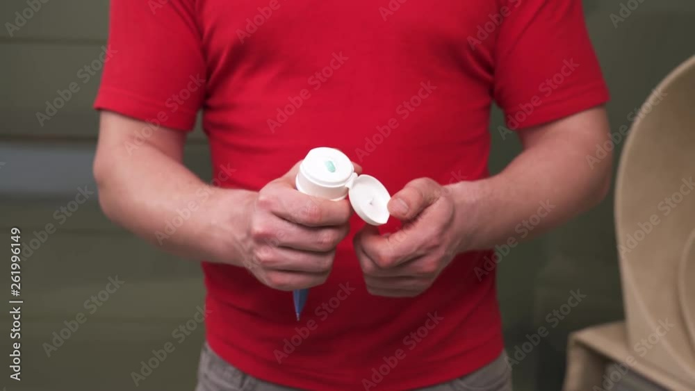 A close-up of therapists hand holding and squeezing a tube with massage lotion for professional usage. Pain relief therapy