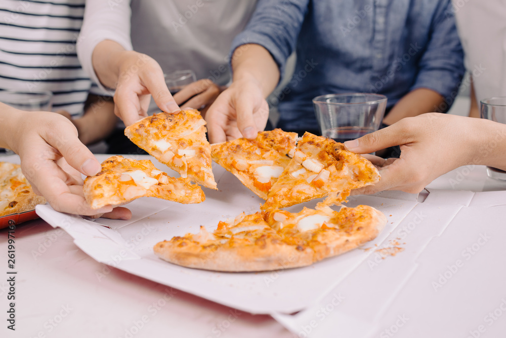 Business team is eating pizza at work while working Business team is eating pizza at work while working