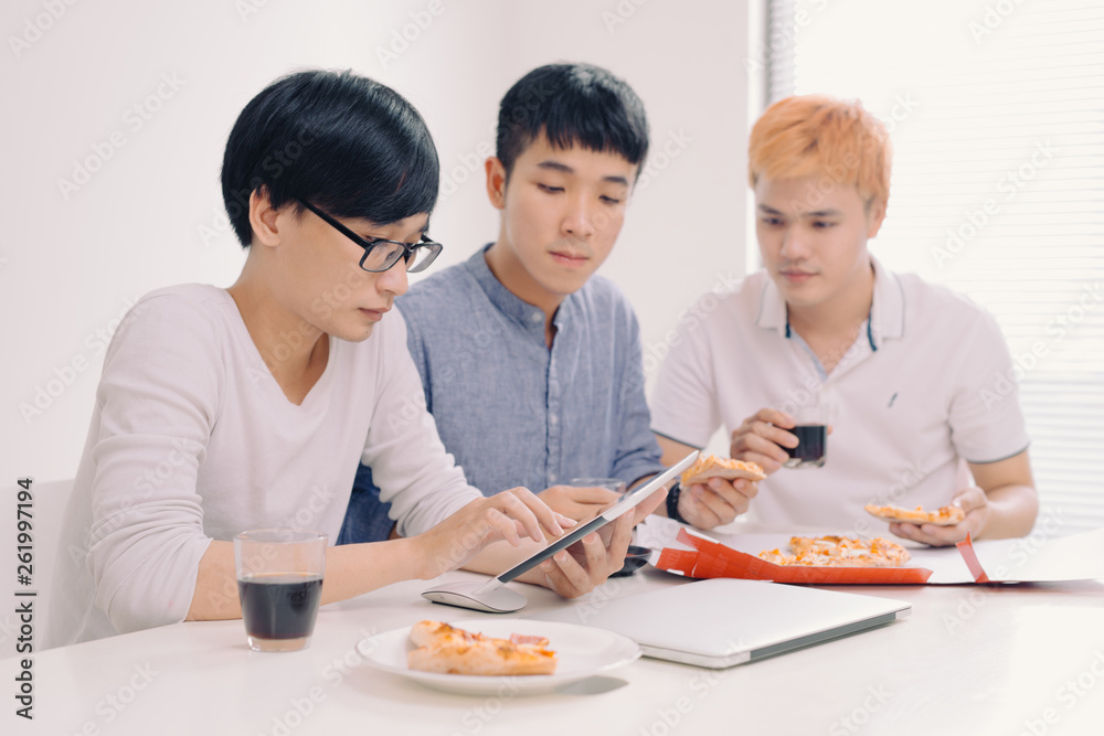 Business team is eating pizza at work while working Business team is eating pizza at work while working