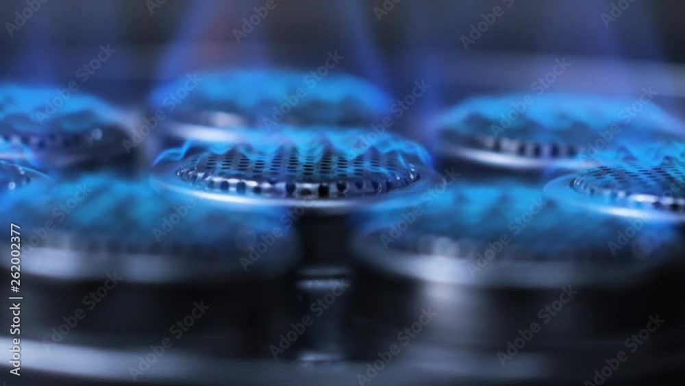 Slow motion Close up shot start ignition to burning fire on gas stove in the dark with dark and grain processed Slow motion Close up shot start ignition to burning fire on gas stove in the dark with dark and grain processed