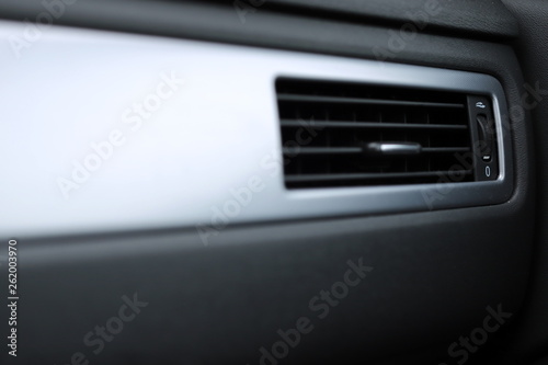 Closeup view on the ventilation grille in the dashboard of a modern car - foreground blanked out blurry - copyspace for text