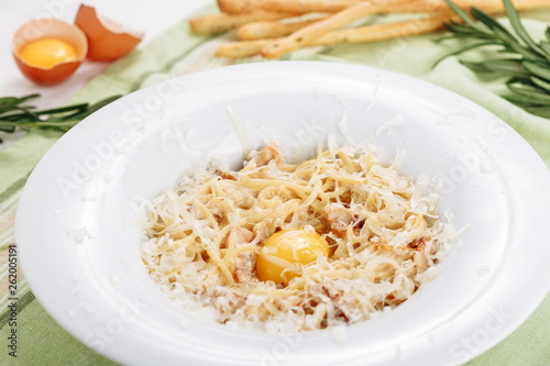 Carbonara Pasta with Ham Egg Yolk and Cheese Side View. Italian Noodles Tagliatelle with Bacon and Parmesan Serving for Gastro Dinner. Homemade Traditional Carbanara Plate for Recipe Photo photo