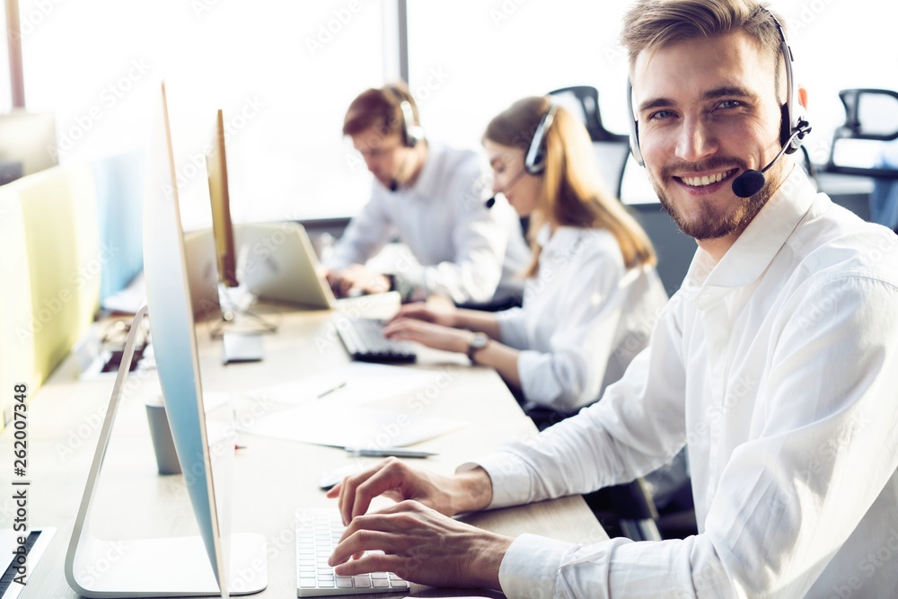 Obraz premium Happy young male customer support executive working in office.