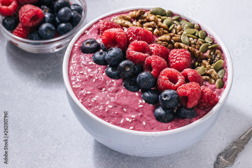 Acai bowl of smoothies with raspberries, blueberries, walnuts, pumpkin seeds and sesame