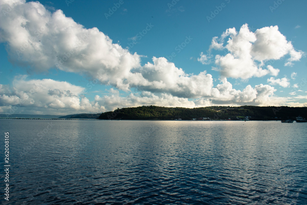 Obraz premium Isla en mar con nubes