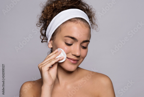 Fotografia A portrait of a young woman cleaning face in a studio, beauty and skin care