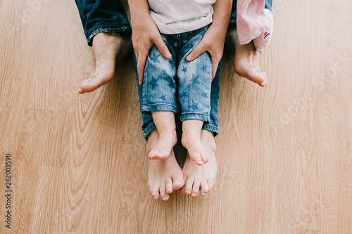 family feet on their home floor with their baby