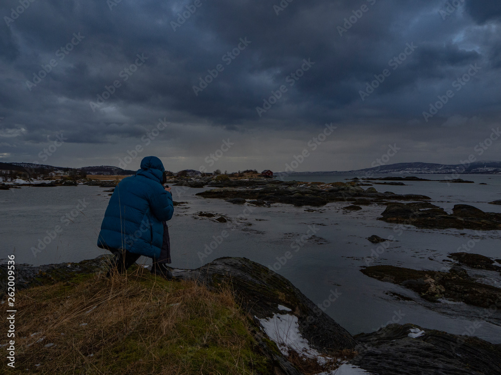 sturm in norwegen an der küste mit fotograf