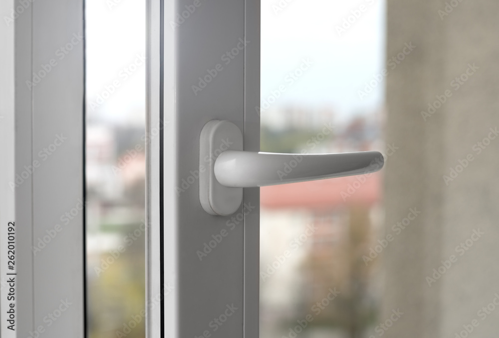 White opened window - Window handle close up White opened window - Window handle close up
