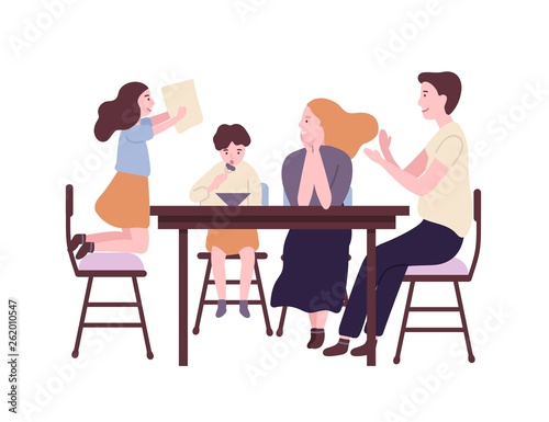 Happy family sitting at dining table and having breakfast, lunch or dinner. S...