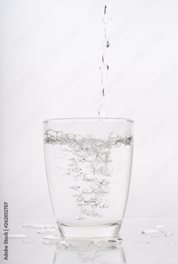 pouring water into a glass isolated on white pouring water into a glass isolated on white