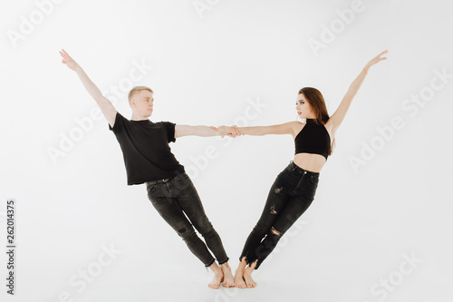Dancing Pose of Professional Caucasian Performer. Caucasian Woman, Man Dancer in Black Denim and Top. Dancer Partner Hold Hand. Contemporary Couple in Allonge Position Isolated on White Background