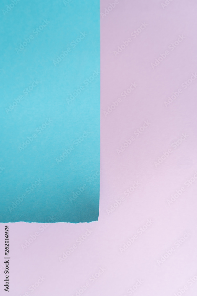 Vertical purple-blue paper background. A piece of blue paper in the up-left corner with torn edges on the background of a sheet of purple paper Vertical purple-blue paper background. A piece of blue paper in the up-left corner with torn edges on the background of a sheet of purple paper