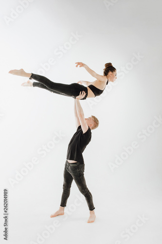 Modern Ballet Dance Couple High Level Lift Pose. Man in Stand, Hold Young Woman Dancer with Two Hand. Caucasian Brunette Skinny Girl Perfomer Flying Position Isolated on White Background
