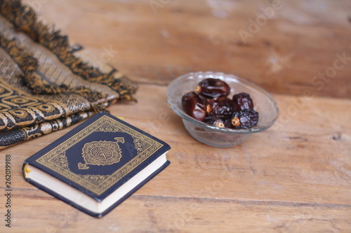 Islamic scriptures and dates on glasses with wooden background - ramadhan concept