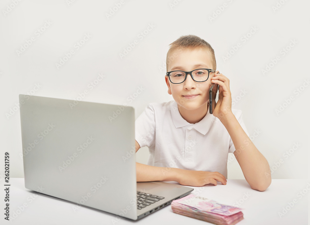 boy with money and laptop at the table on white background boy with money and laptop at the table on white background