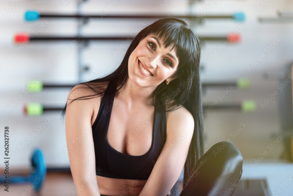 Adorable smiling athletic fitness girl posing in the gym.