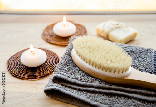 Dry brushing the skin in a pattern with a dry brush, usually before showering help reduce cellulite and remove toxins in human body. Selective focus on firm, natural bristle brush with a long handle.