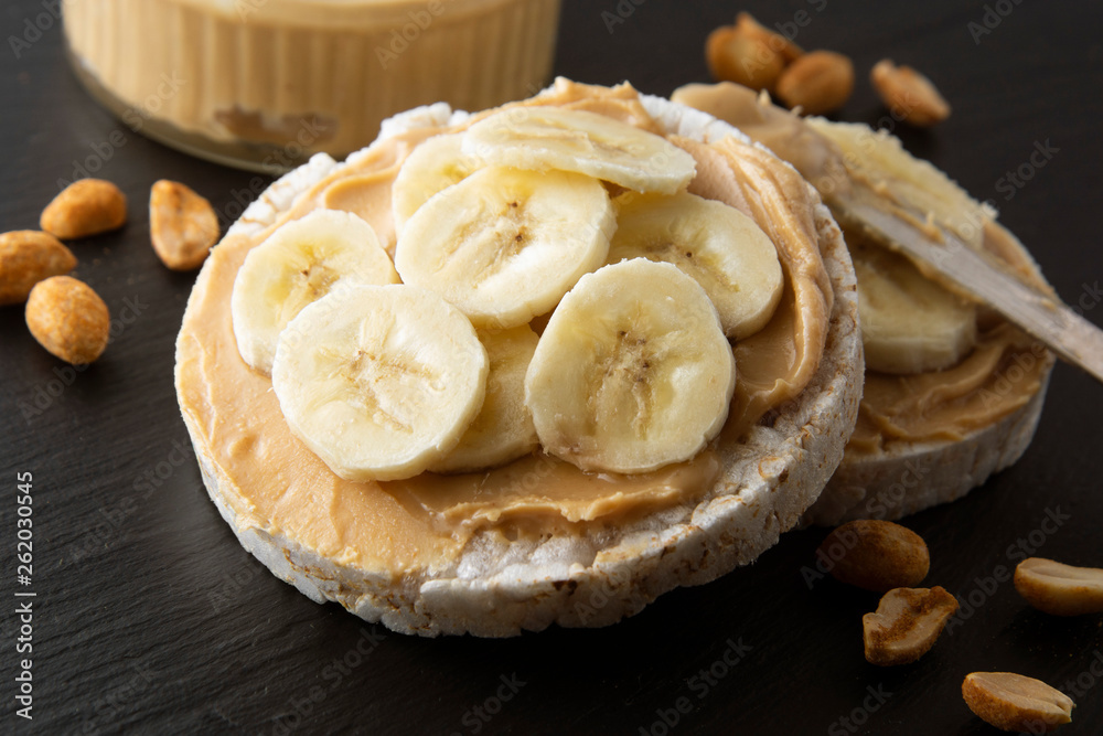Peanut butter and banana on rice cakes, healthy, dietary food. Black background. Peanut butter and banana on rice cakes, healthy, dietary food. Black background.