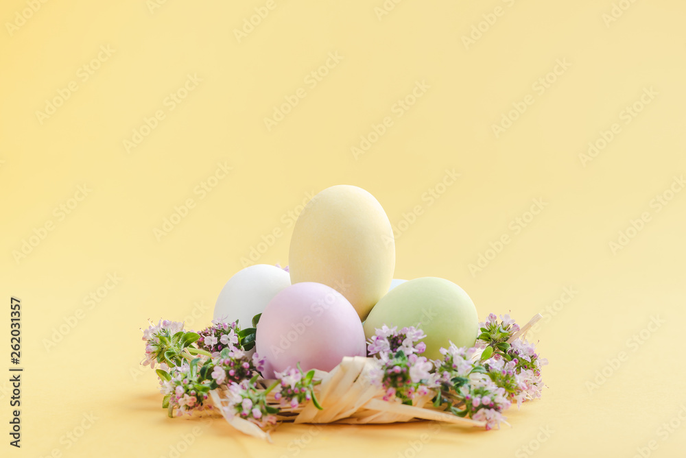 sugared chocolate eggs in a nest decorated with small flowers. Easter gift, pastel colors. Copy space