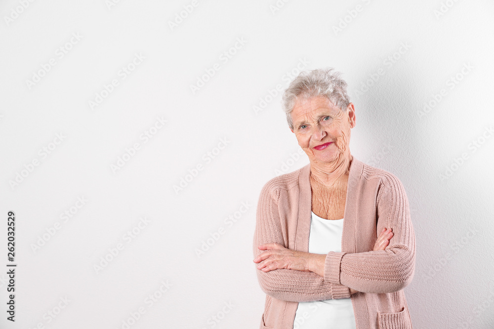 Portrait of grandmother in stylish clothes on light background, space for text Portrait of grandmother in stylish clothes on light background, space for text