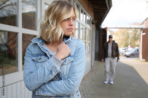Junge Frau fühlt sich von einem Mann verfolgt