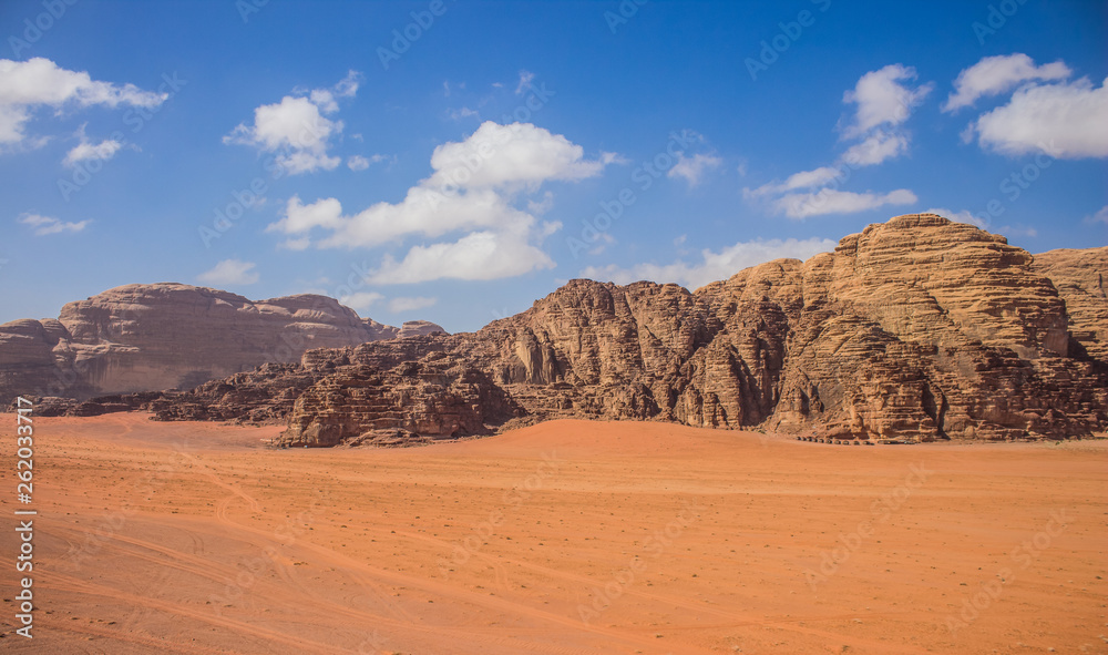 Wadi Rum Jordan Middle East panorama scenery desert landscape sand valley foreground and bare rocky mountain ridge background with vivid blue sky, travel planet and discovery  concept photography