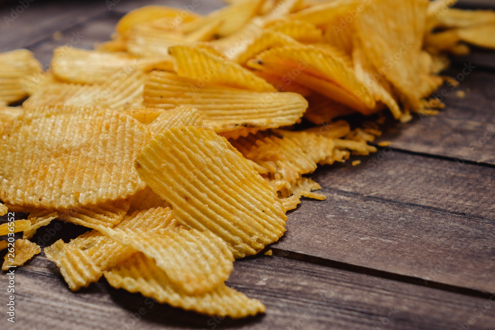 crispy potato chips on wooden background. chips started crispy potato chips on wooden background. chips started