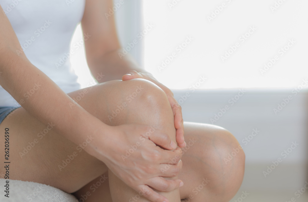 Health care concept. Woman suffering from pain in knee, closeup