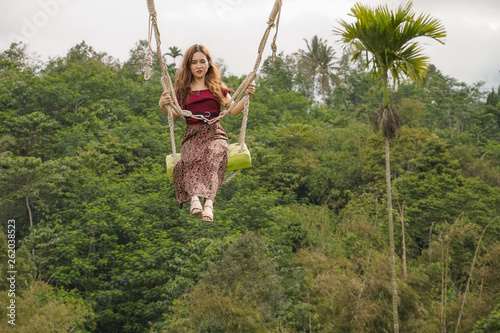 young woman stay on swing in the mountains