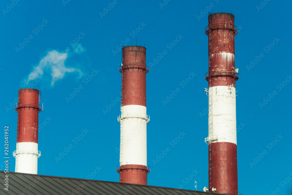 THREE FACTORY PIPES ON THE BACKGROUND OF THE BLUE SKY THREE FACTORY PIPES ON THE BACKGROUND OF THE BLUE SKY