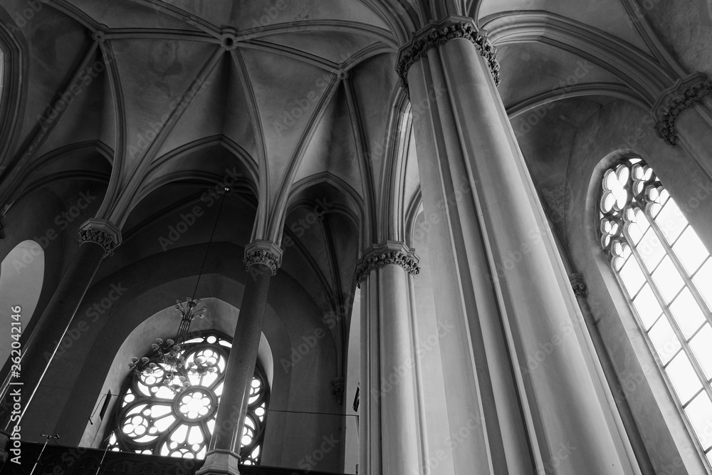 View of gothic medieval cathedral interior with columns and large windows. The Church of Sts. Olha and Elizabeth. Made in black and white colors