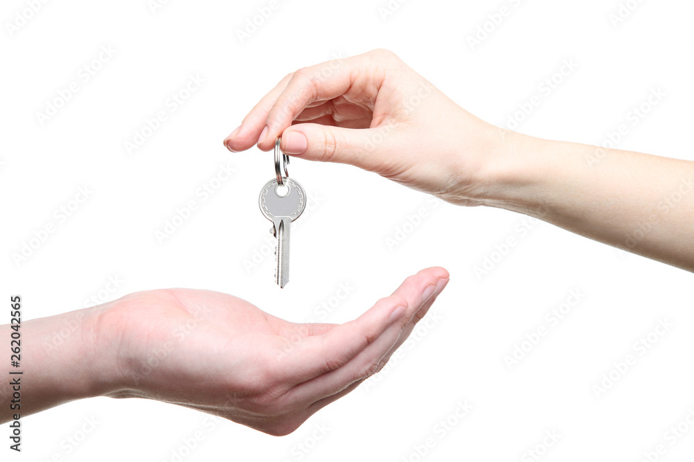 Female hand holding house key on white background Female hand holding house key on white background