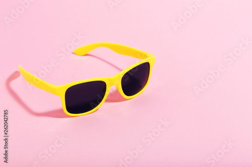 Yellow sunglasses on pink background. Minimalism concept