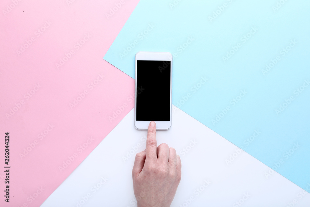 Female finger pressing smartphone button on colorful background Female finger pressing smartphone button on colorful background