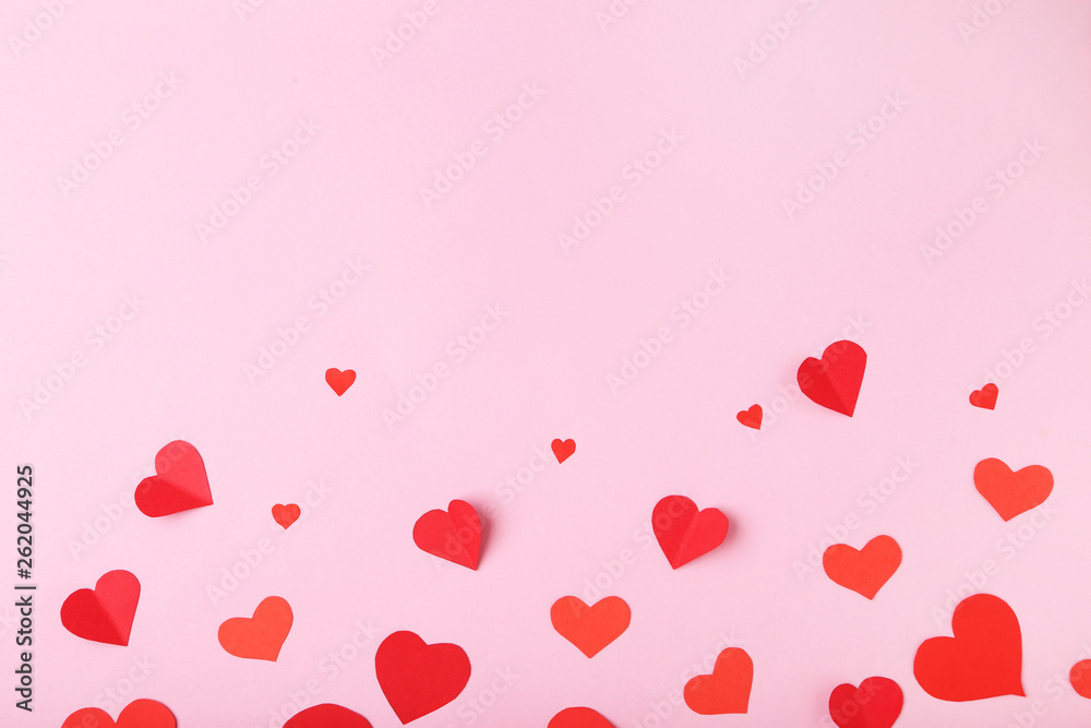 Red paper hearts on pink background