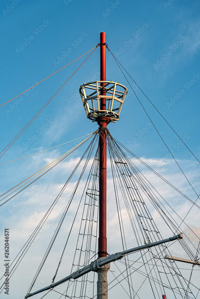 Mast of a ship with its ropes, its tail for the watch and a beautiful cloudy sky behind Mast of a ship with its ropes, its tail for the watch and a beautiful cloudy sky behind