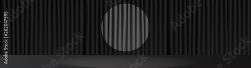 Black stage scene and spot light in center . 