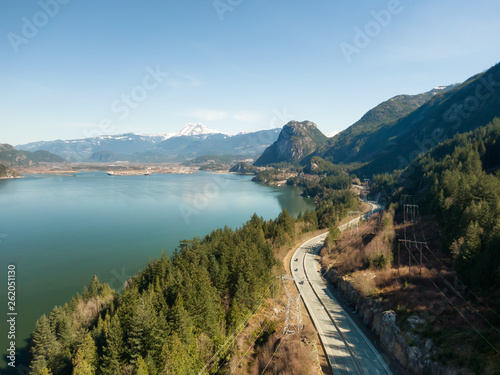 Aerial view of Sea to Sky Highway with Chief Mountain in the background during a sunny day. Taken near Squamish, North of Vancouver, British Columbia, Canada.