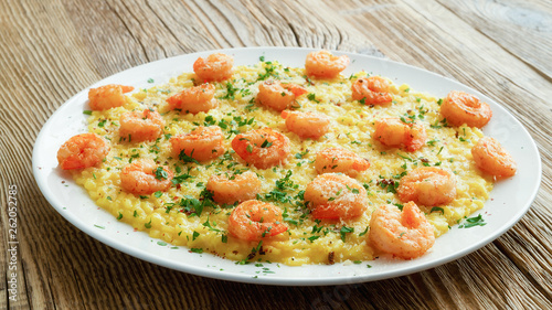 fried scampi with saffron risotto decorated with parmesan, parsley and pink pepper 