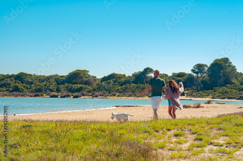 Father and daughter  with a  labrador puppy  at the lake. Family time. photo