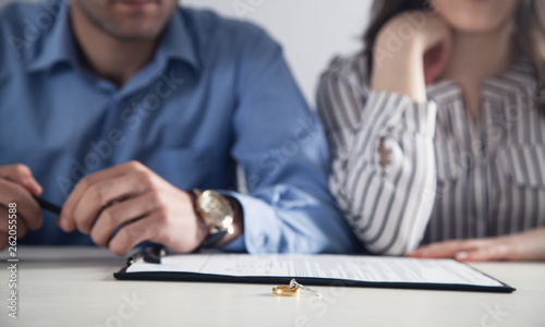 Couple with divorce contract and ring on desk. Divorce photo