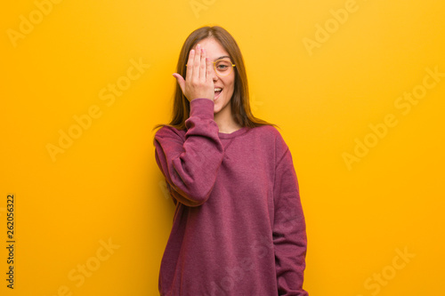 Young casual woman shouting happy and covering face with hand © Asier