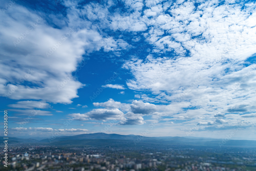 Blue sky with white clouds and horizon line.