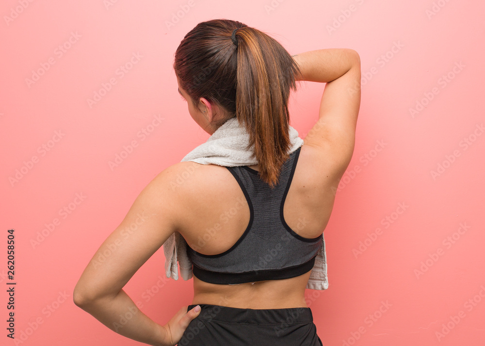 Young fitness woman from behind thinking about something Young fitness woman from behind thinking about something