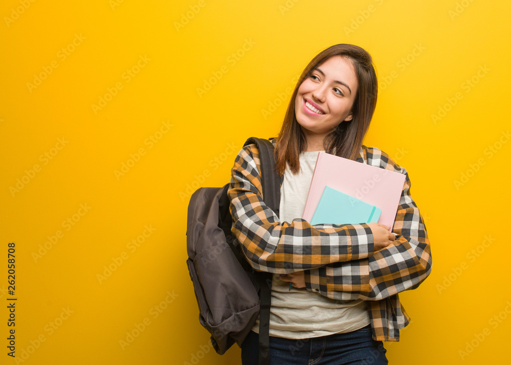 Young student woman smiling confident and crossing arms, looking up Young student woman smiling confident and crossing arms, looking up