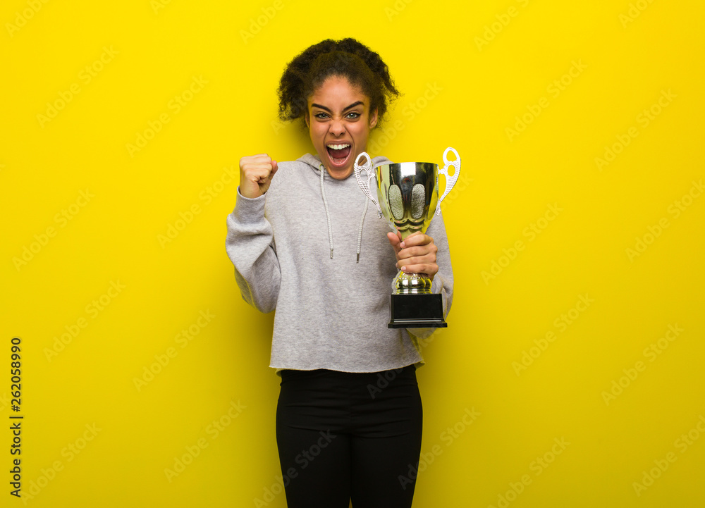 Young fitness black woman screaming very angry and aggressive. Holding a trophy. Young fitness black woman screaming very angry and aggressive. Holding a trophy.
