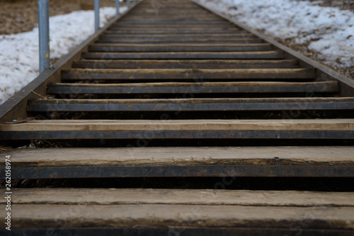 old metal staircase with wooden steps to the hill